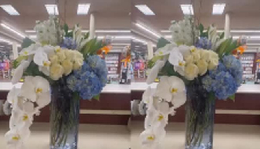 Tall glass vases of white phalaenopsis orchids styled for an event space