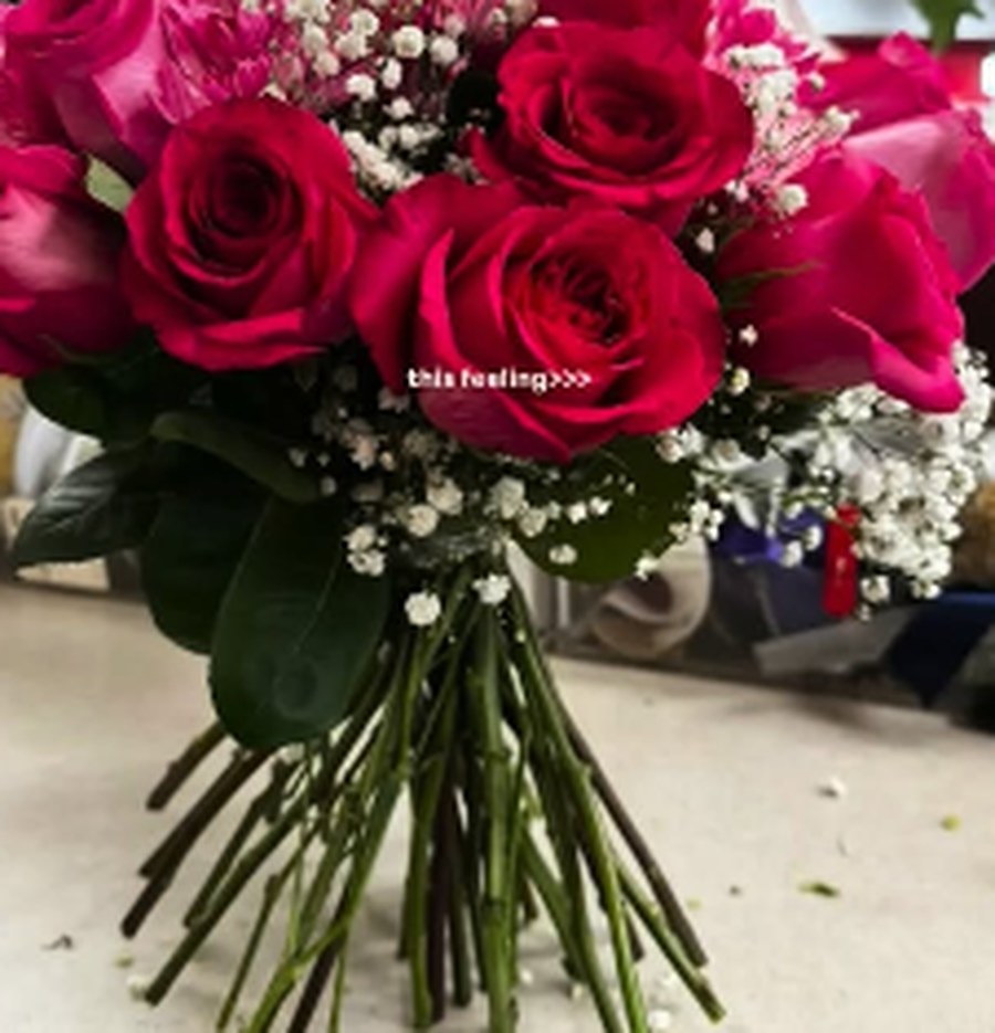 Hand-tied bouquet of deep pink roses with baby's breath